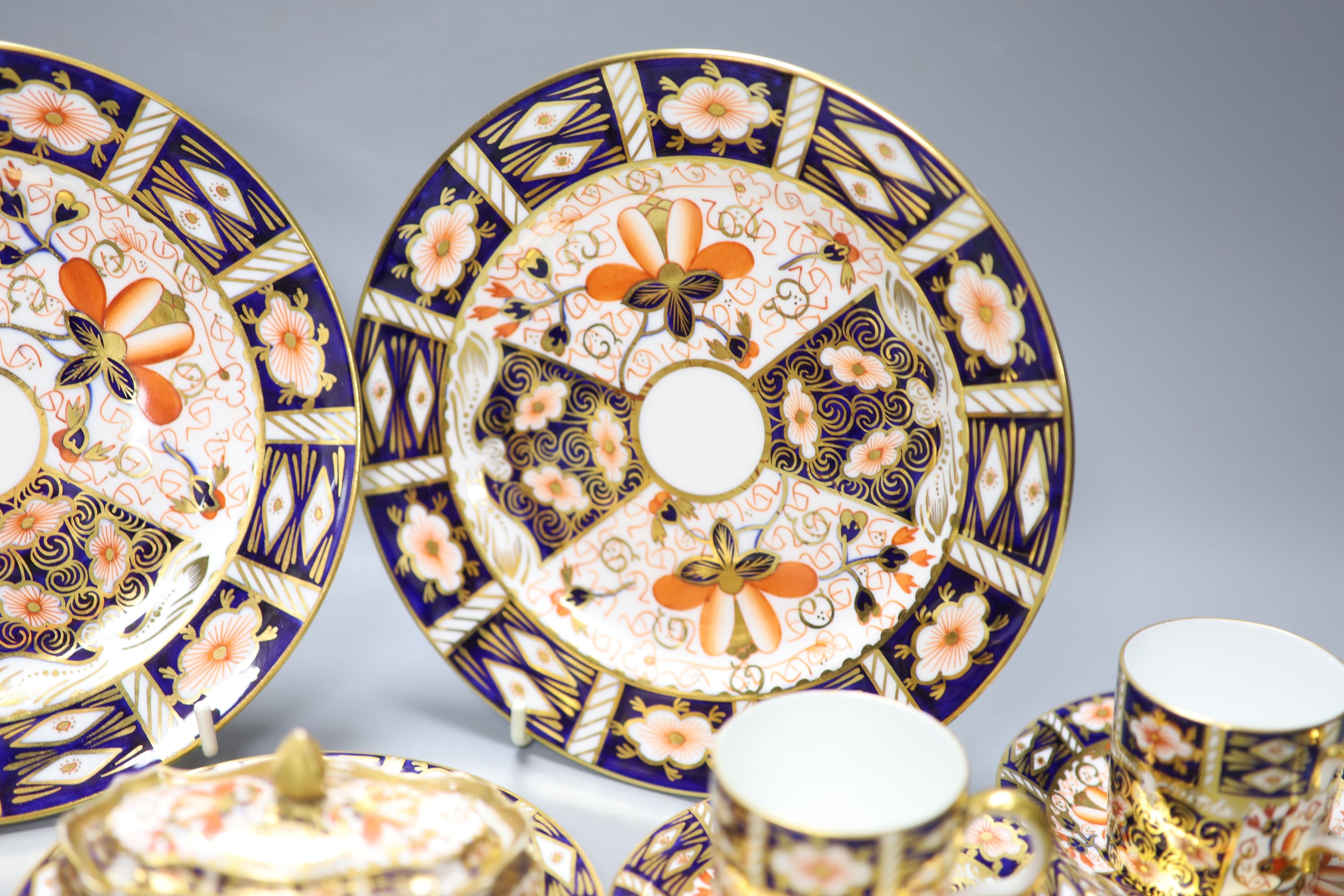 A Royal Crown Derby imari pattern 2451 cup and saucer, three cans and saucers, two bread plates, a small plate, a fan shaped dish and a